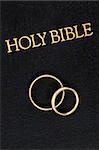 Gold Wedding Rings on the Worn Cover of a Bible