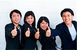 All foung young Asian showing their satisfaction with thumbs up. (Note: main focus on the thumbs, faces are blurred)