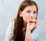 young girl eating homemade pizza