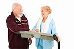 Active senior couple working out at the gym.  Isolated on white.