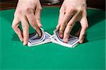 Dealer shuffle cards in casino over green felt