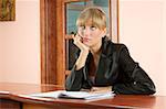 blond girl at  front desk of Hotel reception lost in thought