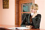 cute blond woman at front desk smiling and talking at phone