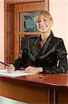 blond girl Hotel reception in black suit smiling