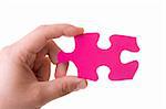 Hand holding a pink puzzle isolated on white
