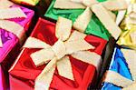 Colorful Christmas gifts wrapped in boxes with ribbons. Shallow depth of field