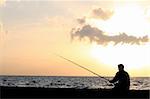 a man fishing at the sunset