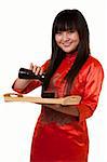 Attractive asian woman wearing orange satin chinese attire holding a tray with a saki cups and jug