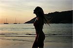 Silhouette of a beautiful young blonde girl on the beach