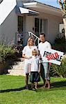 Young Happy Family holding Sold Sign