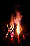 A large log camp fire with sparks