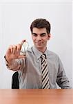Young businessman holding a light bulb and generating ideas with sitting at the table. Focus on light bulb.