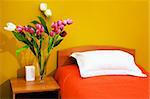 Beautiful tulips at a bed with an orange coverlet