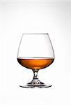 Snifter glass of cognac on white background.