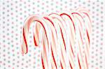 Row of Candy Canes on Red and Green Dotted Background