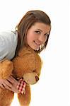 Beautiful teenager holding a teddy bear - isolated on white background