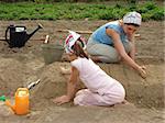 mother and daughter preparing vegetable bed to sowing