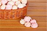 Pink marshmallows in the basket on wooden background