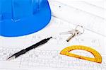 Construction plans with hard hat and drawing tools. Very shallow depth of field