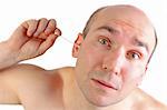 funny looking man cleaning his ear with a q-tip (isolated on white)