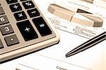 Calculator and steel pen on printed financial data.