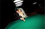 bride and groom play billiard