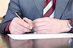 businessman hands on desk signing a document