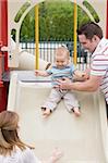 Baby Sliding Down Slide with Parents