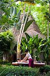 A young woman getting a massage in a tropical spa