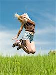 a woman is jumping over the green meadow