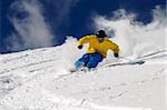 Freeride skier in powder snow against blue sky.