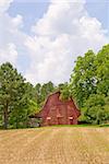 An old rural barn beside a farm field.