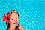 Woman sunbathing by blue swimming pool