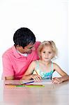 Father and daughter writing together at home