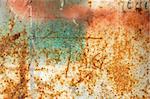 Rusty metal surface with peeled paint and etched numbers. Abstract grunge background.