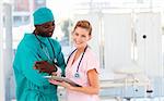 Surgeon and nurse examining a patient report in hospital