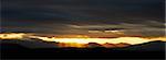 Bright sun beams bursting through very dark threatening clouds