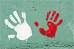 Hand prints with paint on concrete wall