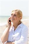 business woman talks by phone on a beach
