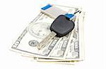 Car key and dollar bills on white background with shallow depth of field