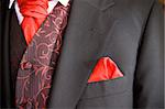 suit jacket of groom and red cravat ascot tie