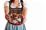 Bavarian Girl wearing original Dirndl and holding Oktoberfest Pretzel in her hands