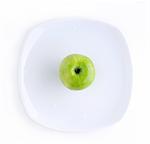 Green Apple in the white plate on the white background
