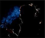 Silhouette or rim light of a Woman lighting a match with blue smoke