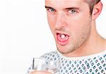 Portrait of a young patient taking a pill and holding a glass of water