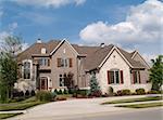 Two story brick and stone residential home with circle driveway.