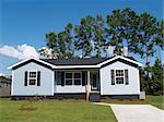 Powder blue low-income single-story home with porch.