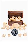 Guidance to wealth concept using compass and golden nuggets with treasure chest on background