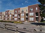 New townhouse or condo type homes made of different shades of brick and vinyl siding.