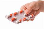 Woman hand holding a tablet with orange capsules